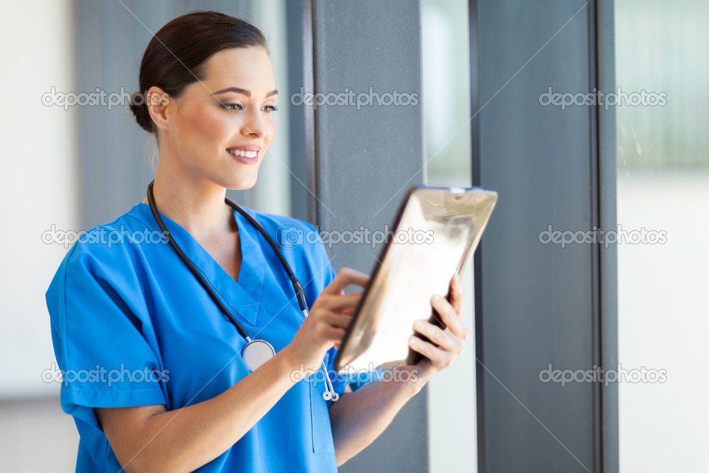 Beautiful female medical doctor using tablet computer in hospital