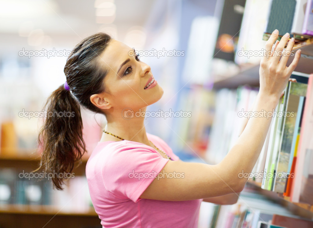 Young woman searching for a book in bookstore