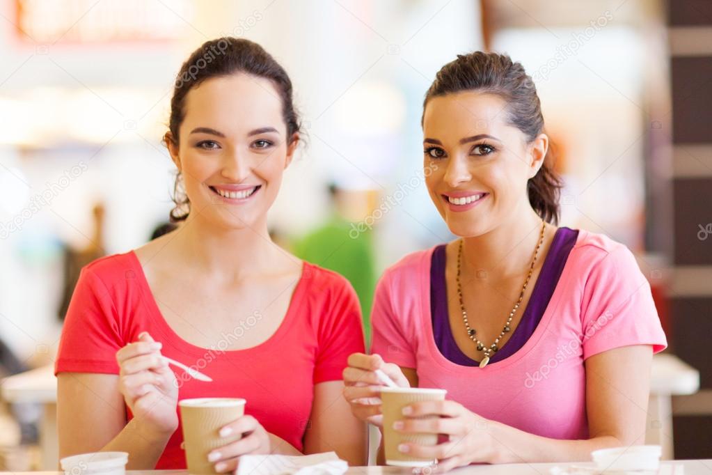 Two women friends having drinks in cafe