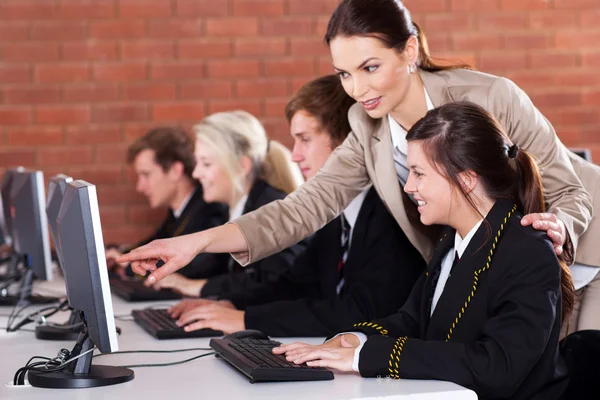 Profesora de secundaria enseñando en sala de computadoras — Foto de Stock