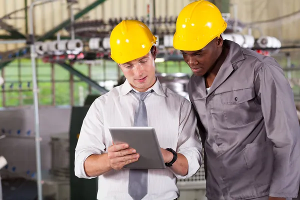 Gerente de fábrica y trabajador mirando tableta ordenador — Foto de Stock