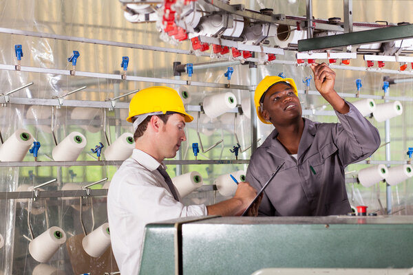 Textile factory worker and quality controller checking quality