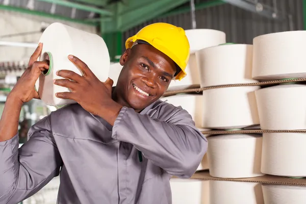 Trabajador de la fábrica textil que lleva materia prima en su hombro — Foto de Stock