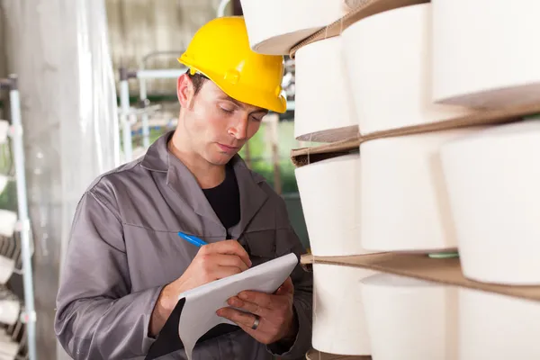 Textile worker taking stock in factory — Stock Photo, Image