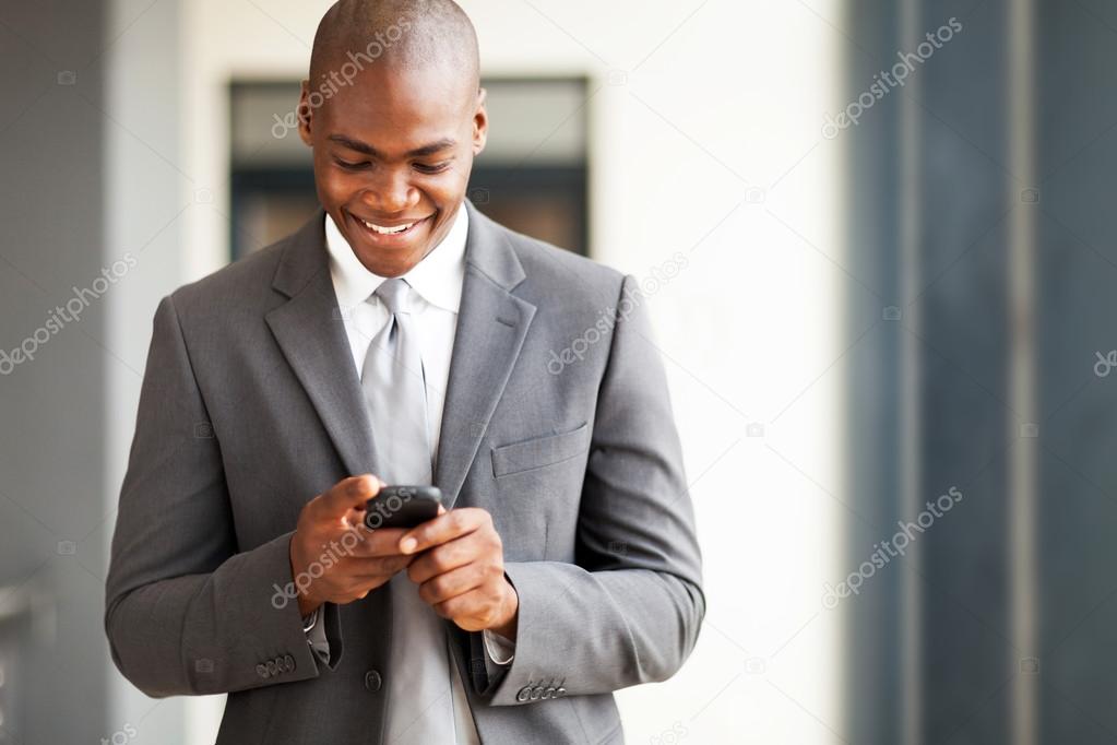 Young african american businessman reading email on smart phone