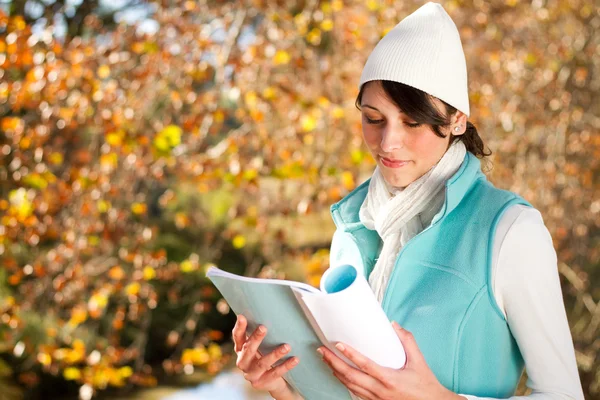 Joven estudiante universitaria hermosa lectura libro en bosque de otoño —  Fotos de Stock