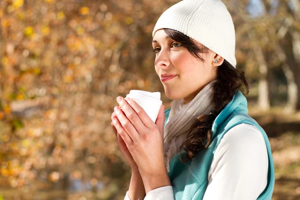 Attraktiv kvinna dricker kaffe i höst skog — Stockfoto