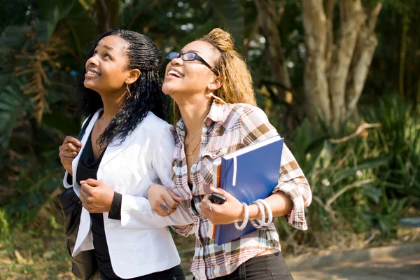 Twee gelukkige vrouwelijke Afrikaanse studenten lopen naar klas — Stockfoto