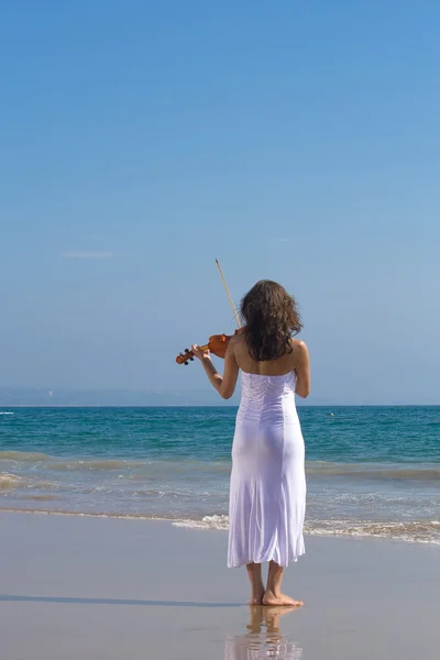 Mladá žena houslista hrající housle na pláži — Stock fotografie