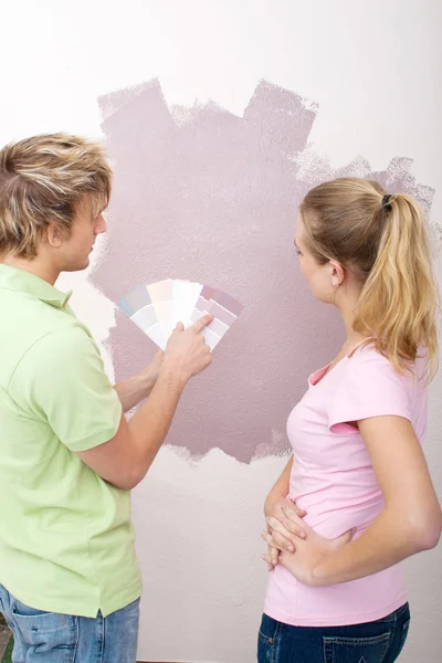 Young couple choosing paint color for their new home — 스톡 사진