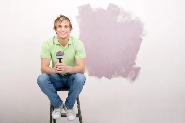 Jovem feliz pintando a parede — Fotografia de Stock