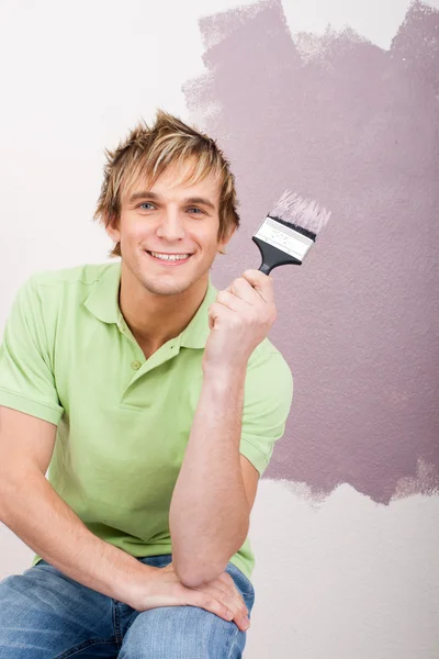 Schöner junger Mann bemalt die Wand — Stockfoto