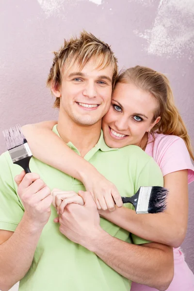 Joven feliz pareja pintura nuevo hogar — Foto de Stock