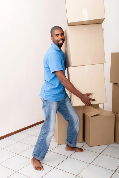 African man carrying boxes moving to new home — Stock Photo, Image
