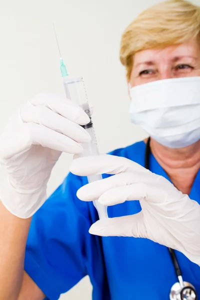 Female senior nurse holding syringe — Stock Photo, Image