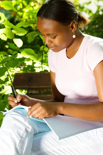 Female african american student studying outdoors — Stock Photo, Image