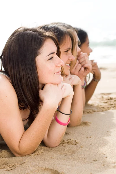 Groep van tiener meisjes op het strand liggen — Stockfoto