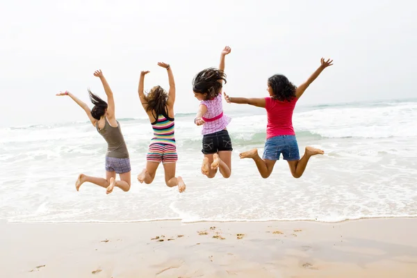 Grupp tonåring flickor hoppa på stranden — Stockfoto