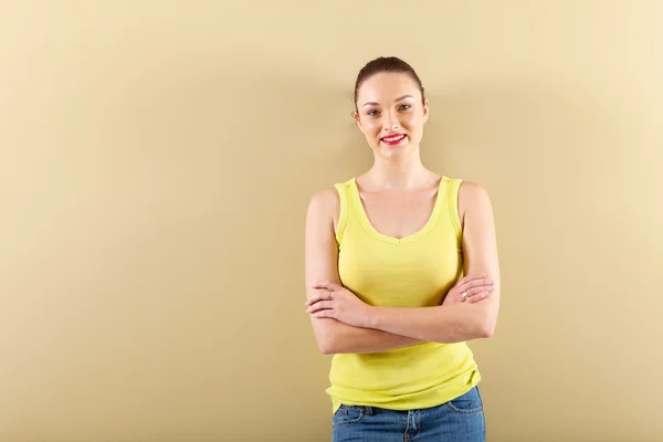 Young woman standing in front of wall — Stock Photo, Image