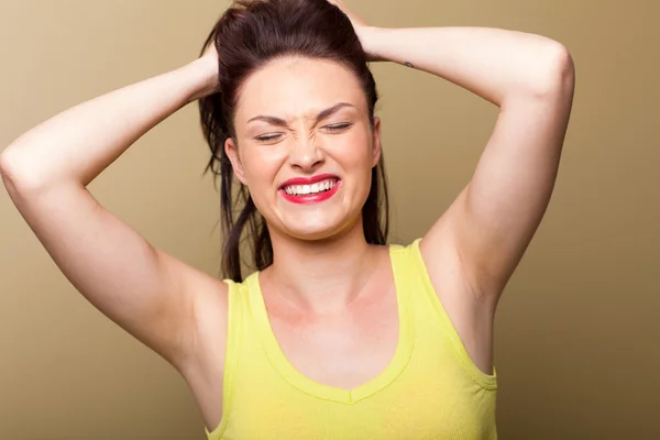 Frustrated young woman grabbing and pulling her hair — Stock Photo, Image