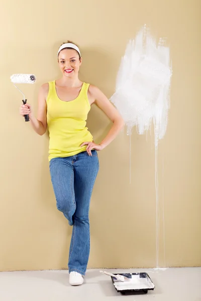 Longitud completa de la mujer joven pintando la pared — Foto de Stock