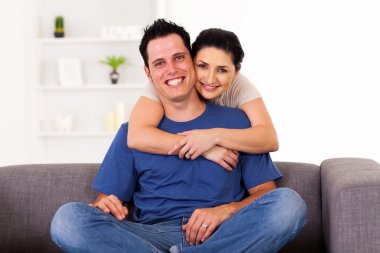 Genç çift evde kanepede sarılma sevgi dolu