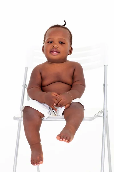 Bonito menino africano sentado na cadeira branca — Fotografia de Stock