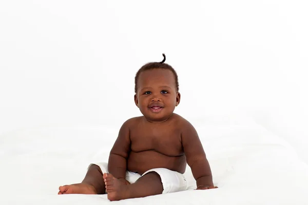 Cute african american baby boy sitting on bed — Stock Photo, Image