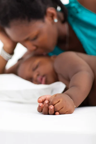 Африканская американская мать целует спящего ребенка — стоковое фото