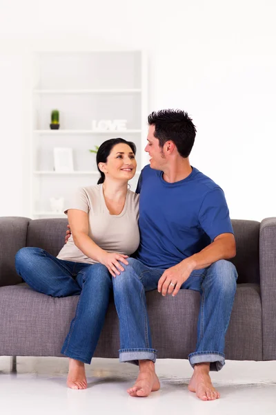 Jeune couple assis sur le canapé à la maison — Photo