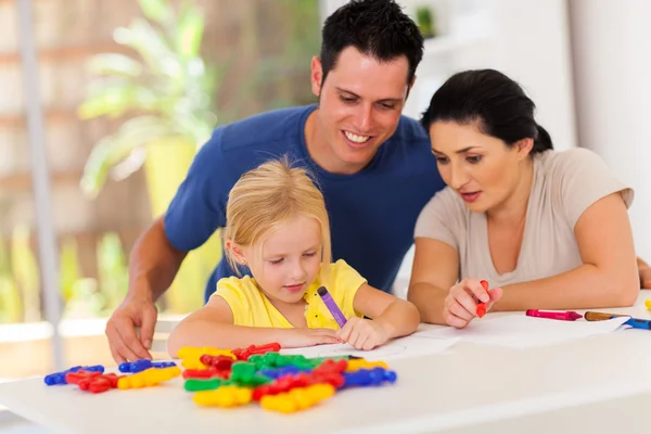 Gelukkige ouders kijken naar kleine dochter tekening afbeelding — Stockfoto