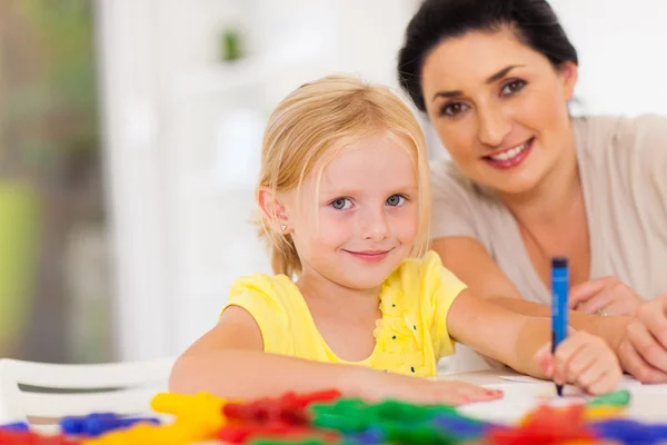 Söt liten flicka ritning med mamma hemma — Stockfoto