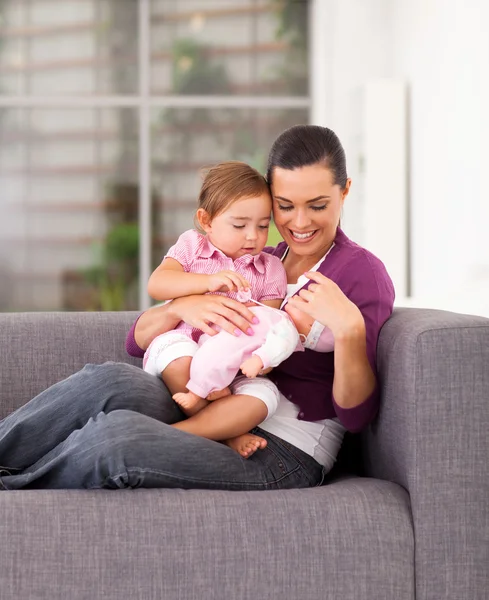 Glad mamma spelar toy med dotter på soffan hemma — Stockfoto