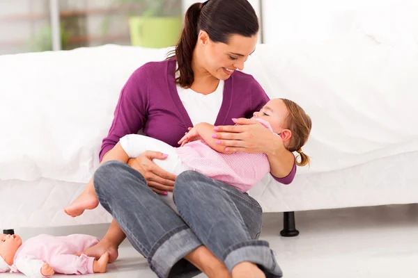 Caring mother rocking her baby girl to sleep — Stock Photo, Image