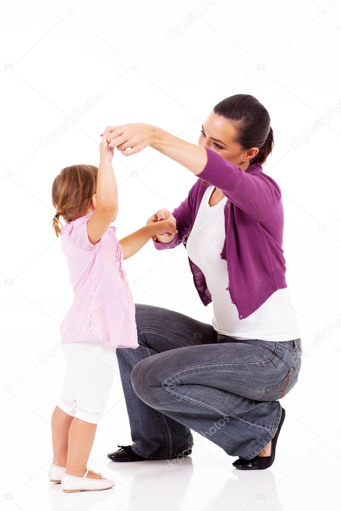 Young mother playing with little daughter on white
