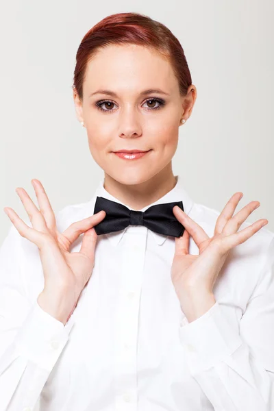 Elegante junge Kellnerin hält sich an Fliege fest — Stockfoto