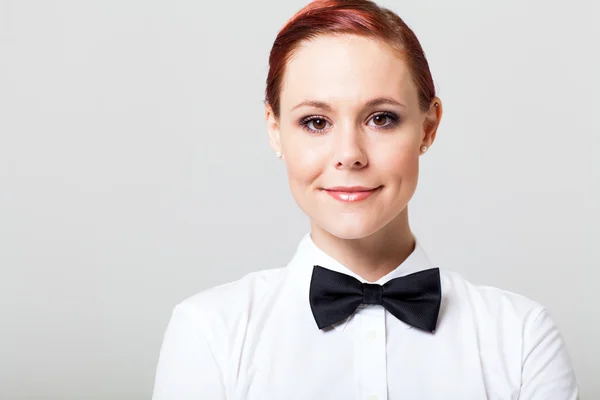 Beautiful young waitress with bow tie studio portrait — Stock Photo, Image