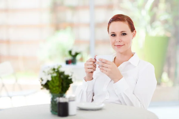 Çekici genç bir kadın cafede kahve içer — Stok fotoğraf