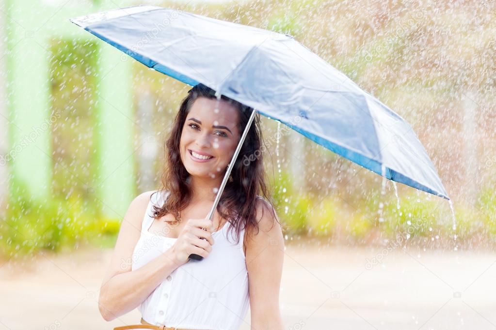 Pretty young woman in the rain with umbrella