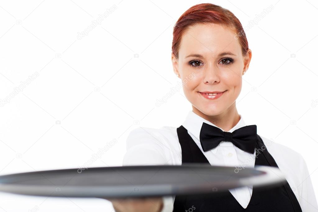 Cute young waitress holding an empty tray on white