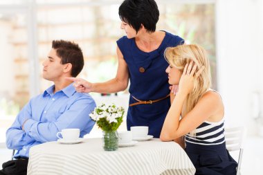 Mother pointing finger at son-in-law as she took daughter's side when couple fighting clipart
