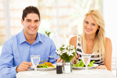 Young couple having lunch in restaurant clipart