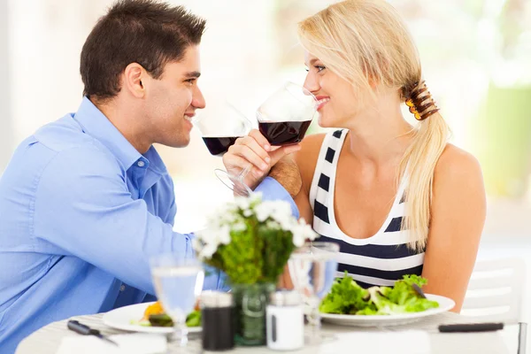 Liefdevolle jong koppel het drinken van wijn in restaurant — Stockfoto