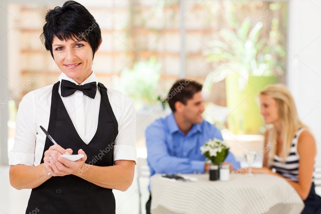 Elegant mature waitress working in restaurant