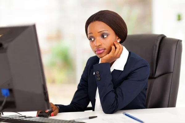 Pensativa mujer de negocios afroamericana mirando la pantalla de la computadora en la oficina — Foto de Stock