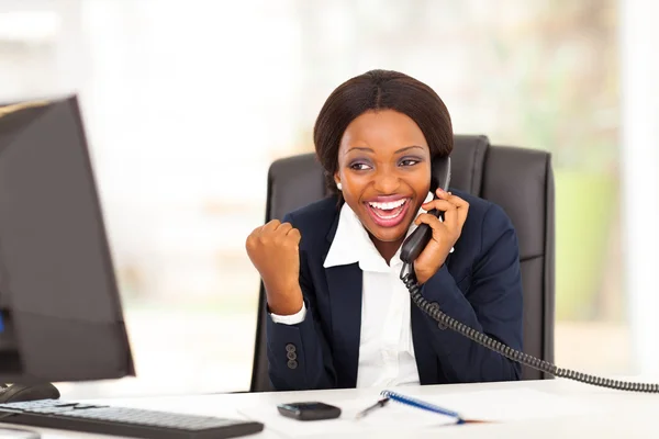 Joven mujer de negocios afroamericana recibiendo noticias emocionadas en el cargo —  Fotos de Stock