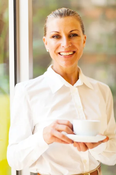 Vrolijke senior zakenvrouw met koffie in office — Stockfoto