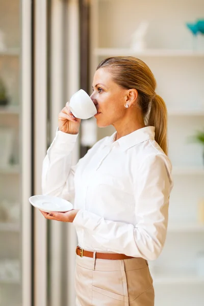 Seniorin trinkt Kaffee im Büro — Stockfoto