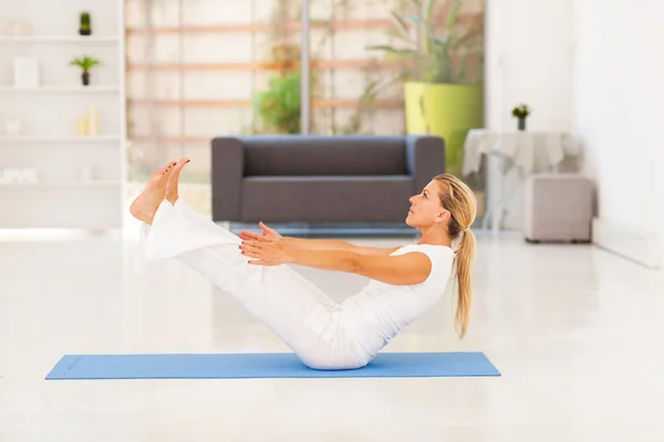 Střední věk žena dělá jóga cvičení doma — Stock fotografie
