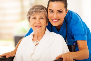 Happy senior woman on wheelchair with caregiver clipart